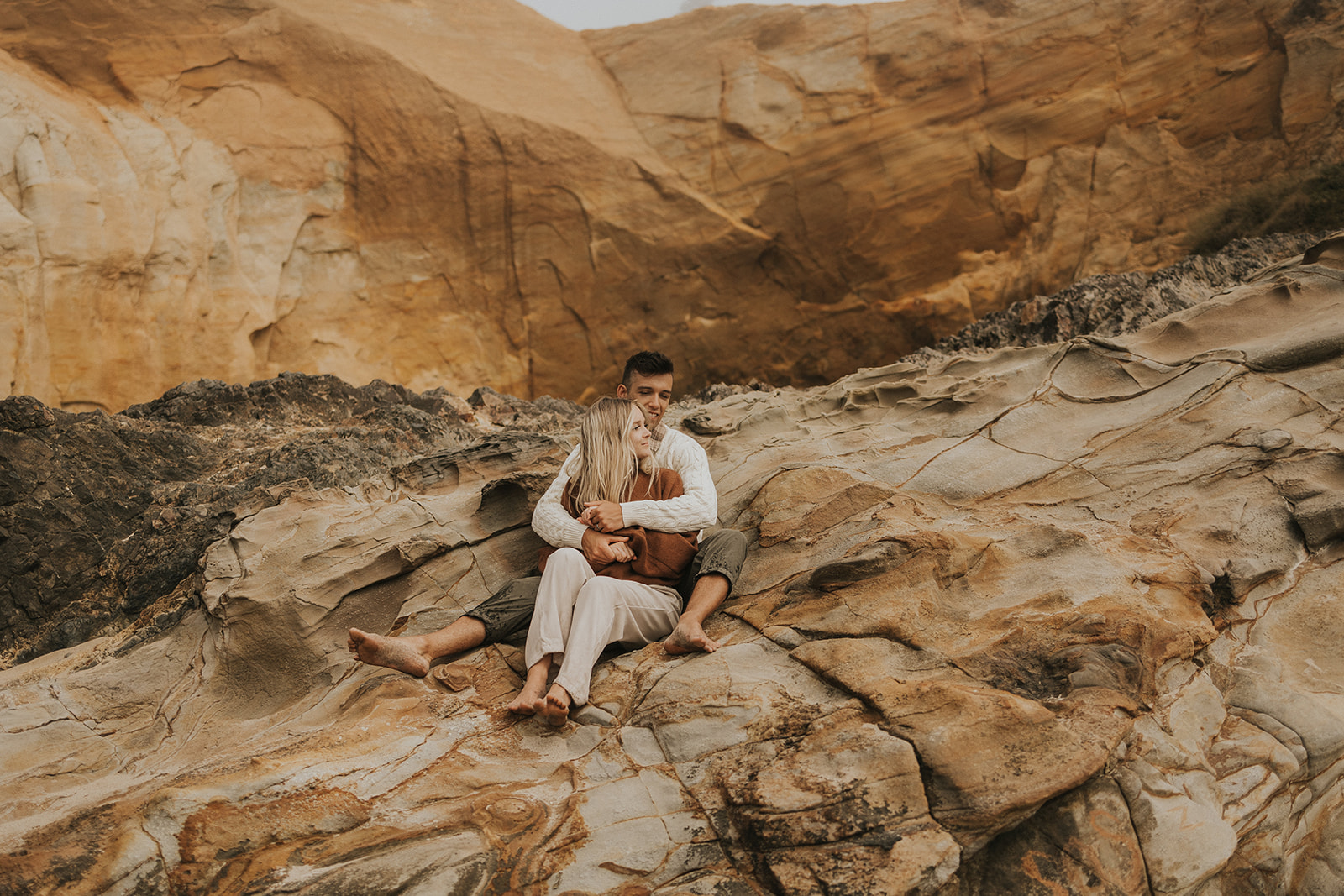 Couple sitting on rocks in oregon