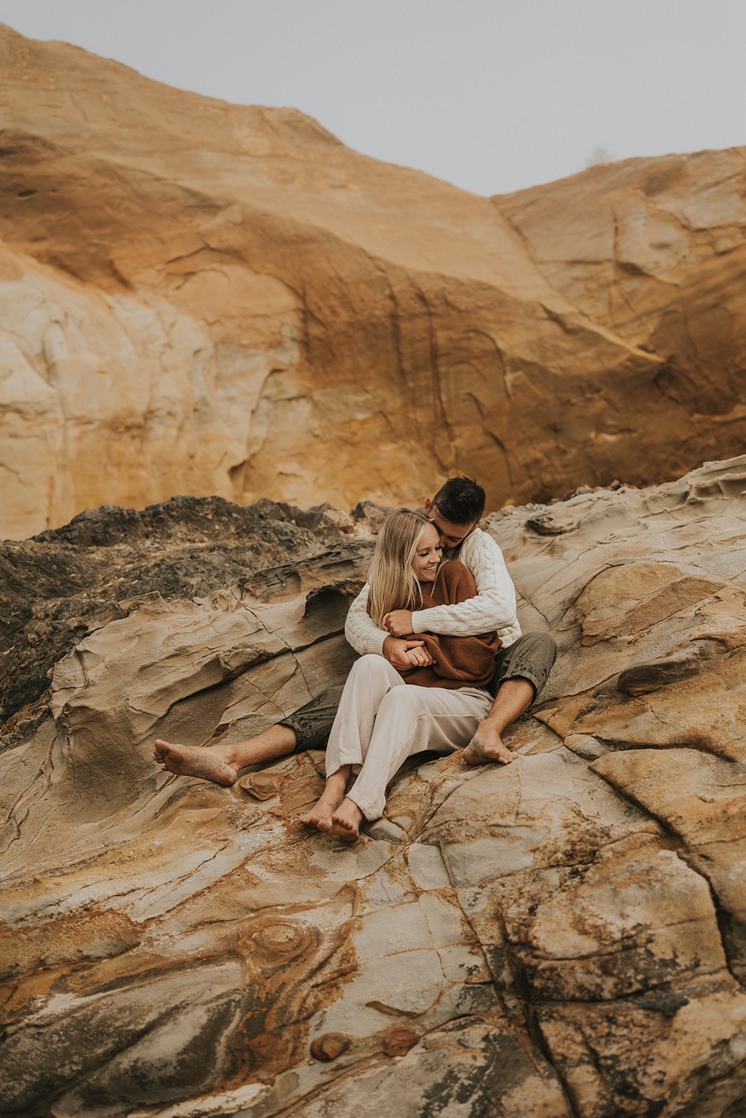 couple sitting on the rocks in oregon beach