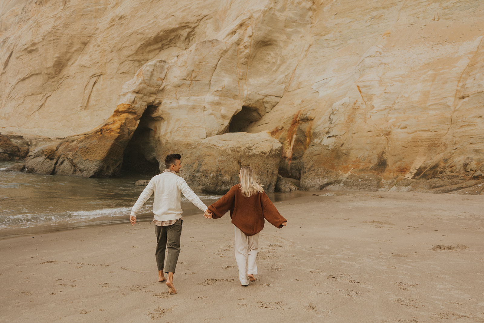 couple walking on a beach on the oregon coast