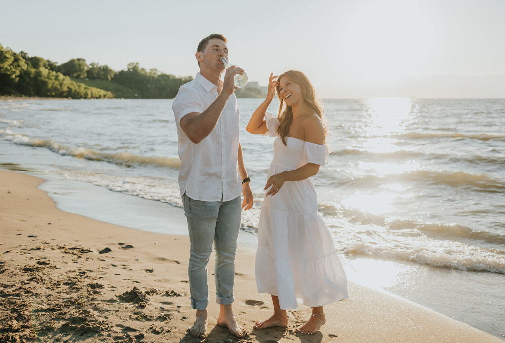 Man drinking out of bottle of champagne during beach photoshoot