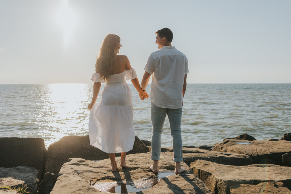 Newly engaged couple holding hands during their beach engagement session