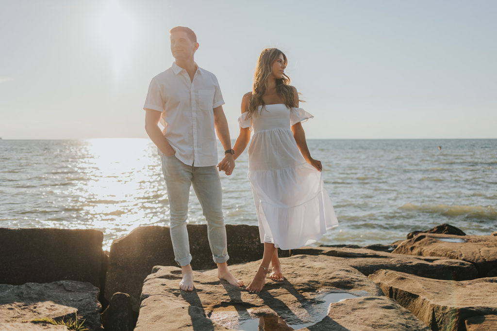 Couple posing on beach rocks for photoshoot