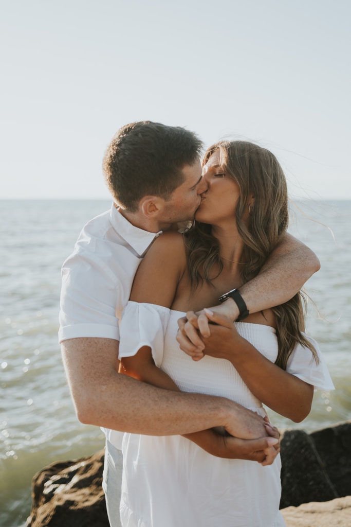 Couple kissing during engagement photoshoot beach session