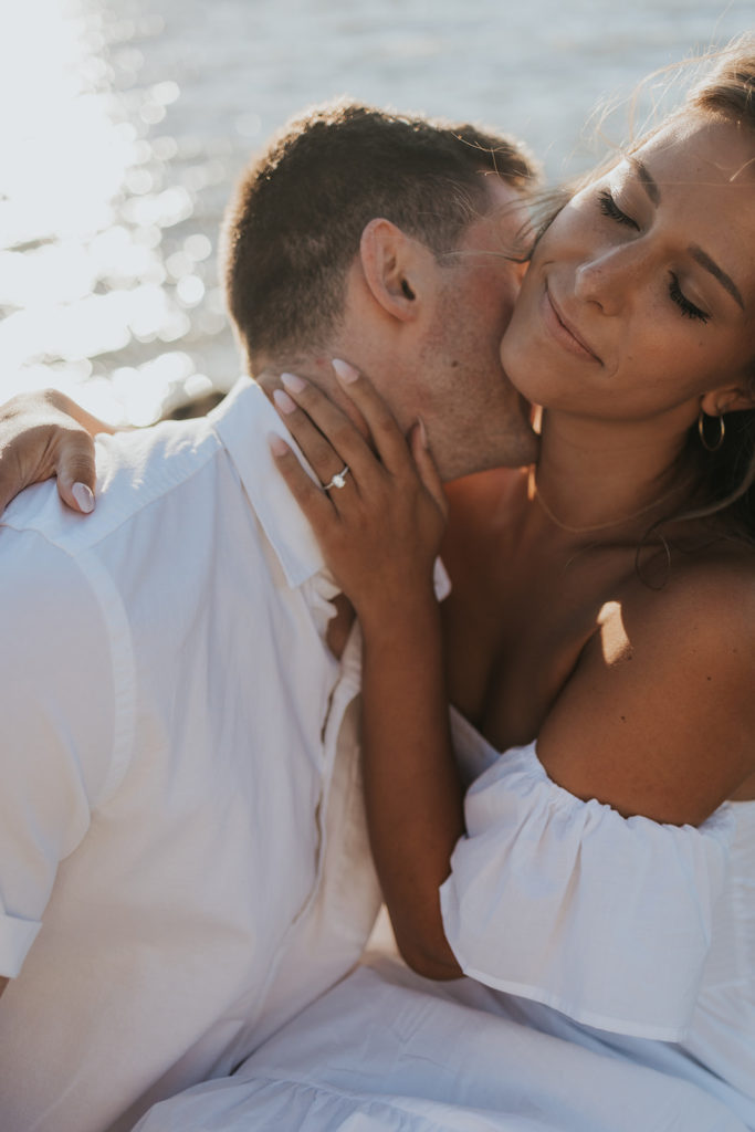 Man kissing womens neck during engagement photoshoot beach session