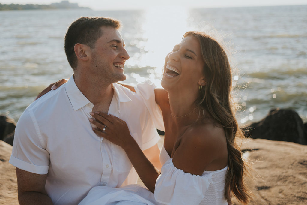 Newly engaged couple laughing during engagement photoshoot