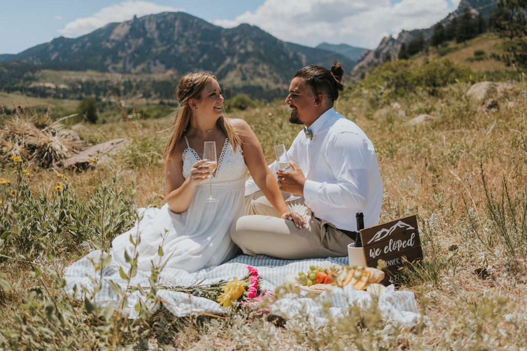 Bride and groom having picnic during Colorado elopement 