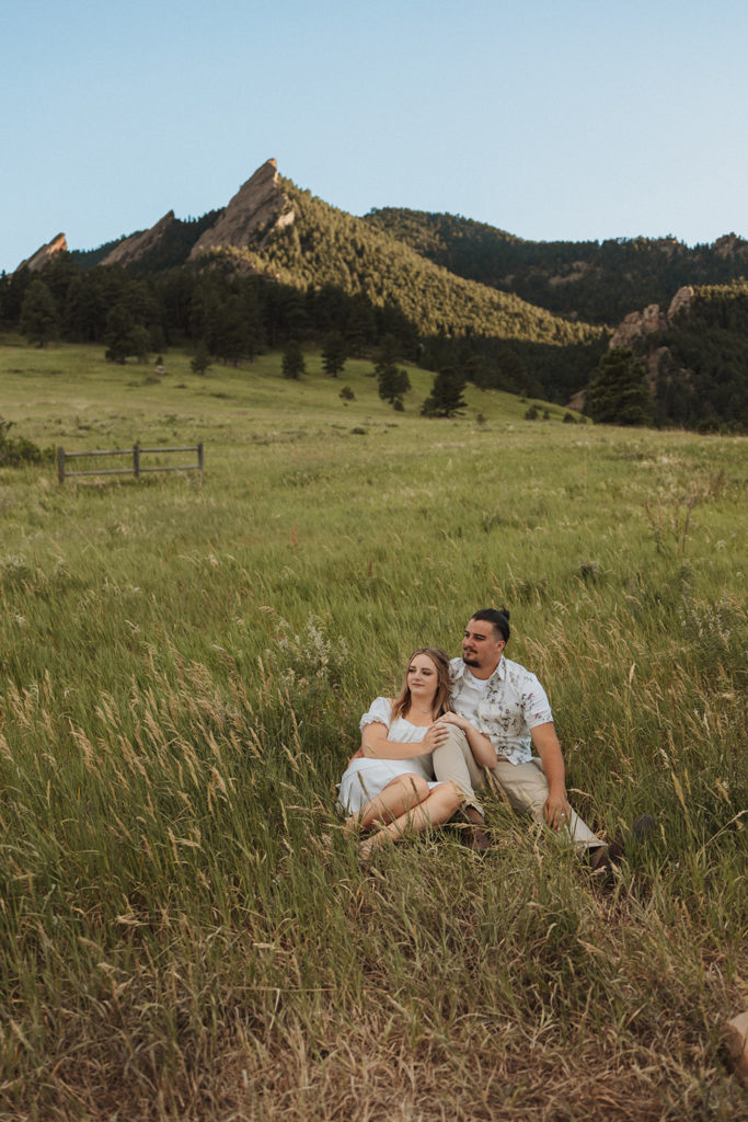 Couple sitting in the grass during photoshoot