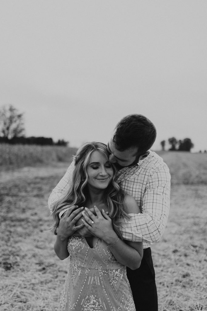 Man kissing woman in black and white engagement photo