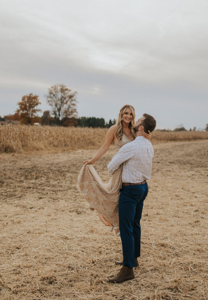 Newly engaged couple posing in Ohio field for engagement photos
