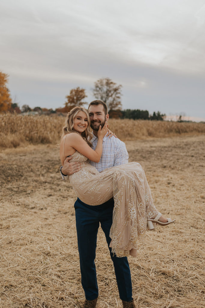 Man holding woman for fall engagement photoshoot