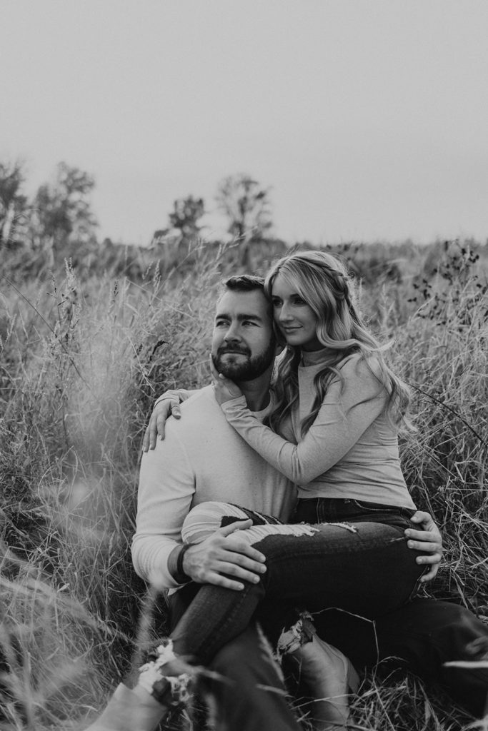 Woman sitting on mans lap for engagement photos