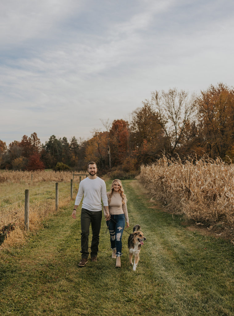 Newly engaged couple walking with their dog for engagement photoshoot with a dog