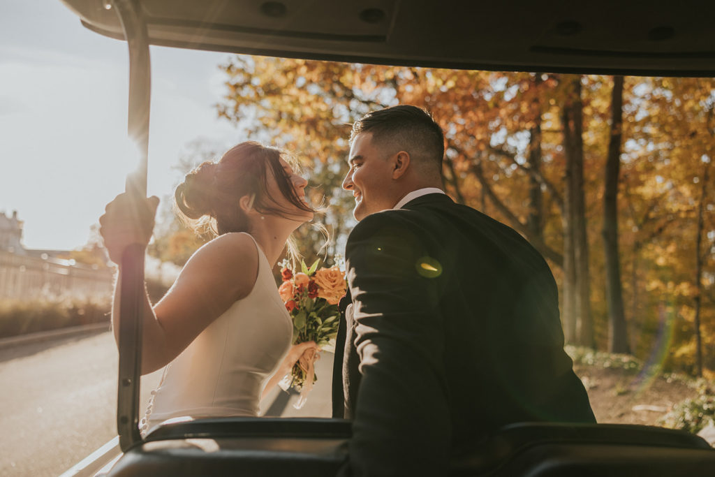Bride and groom kissing on golf cart