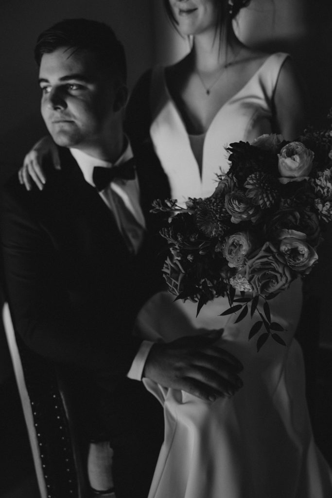 Bride sitting in grooms lap for wedding portraits 