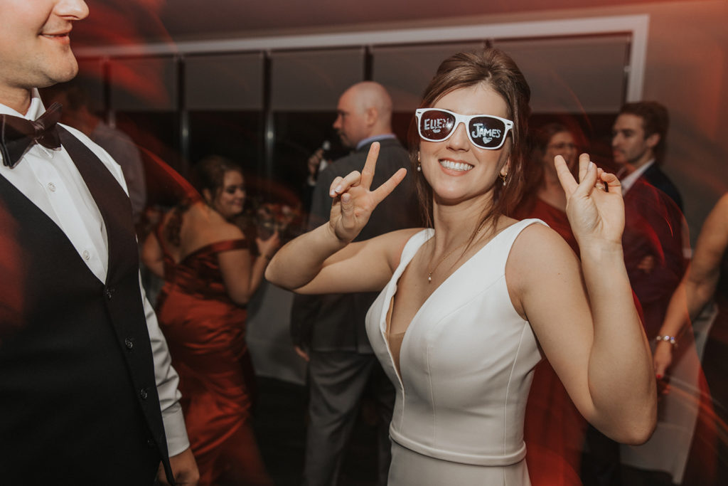 Bride dancing with sunglasses on at wedding reception 