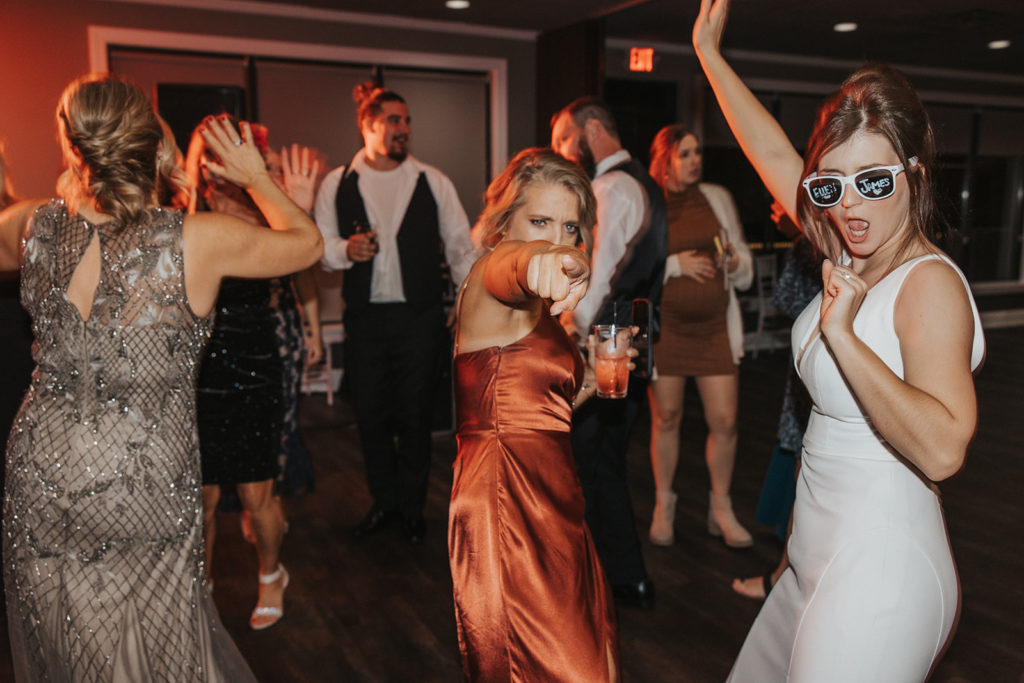 Bride dancing with bridesmaid during wedding reception 