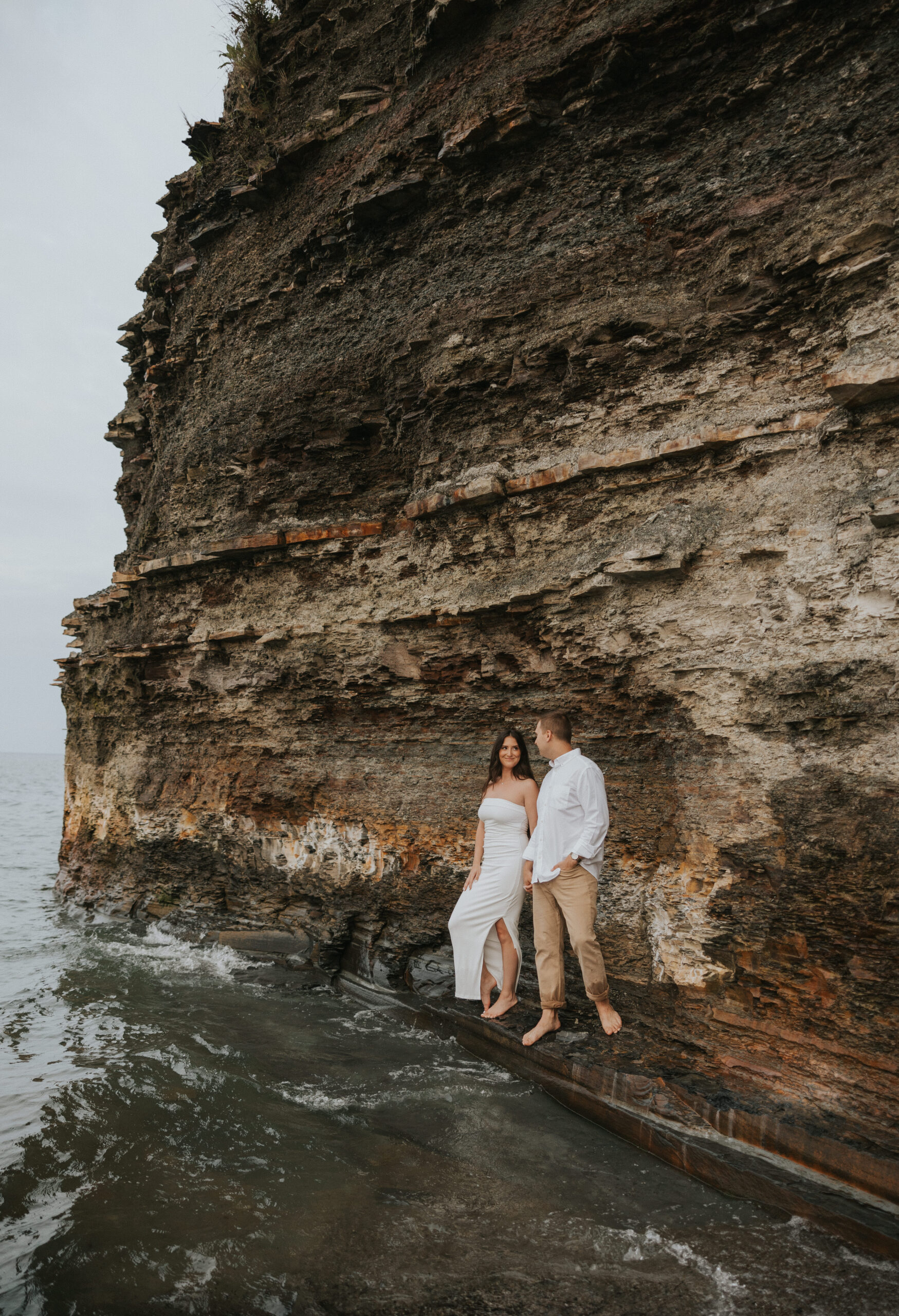 Couple standing on a rock by water